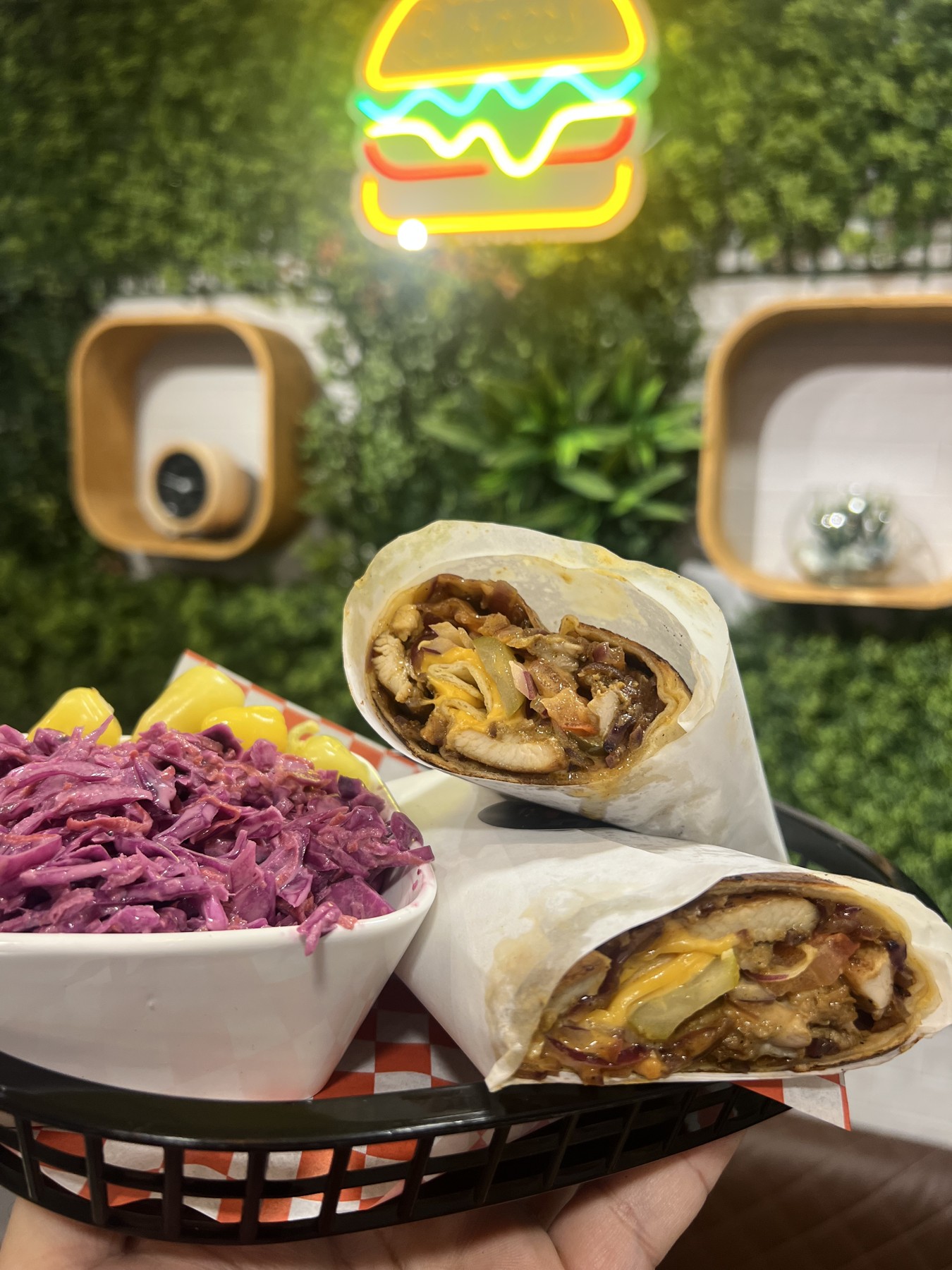 Wraps und Beilagen im Laden vor unserer grünen Wand mit Burger-Neon